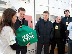 Diego Santilli y Mauricio Macri observan un cartel de Basura Cero en manos de una activista de la organizacin