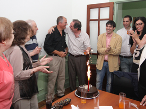 Mientras los presentes aplauden, Marcelo Ruiz abraza a Adrin Hilarza luego de encender la velita de la torta de los 10 aos de AIPH.